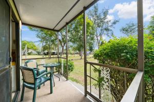 a balcony with a table and chairs and a view of a park at Esk Caravan Park & Rail Trail Motel in Esk