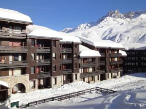 a building covered in snow with mountains in the background at Appartement Méribel, 2 pièces, 4 personnes - FR-1-182-240 in Les Allues