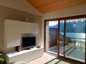 salon z telewizorem i dużym oknem w obiekcie Bellavista Giulia on Lake Como w mieście Dervio