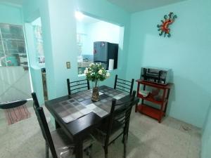ein Esszimmer mit einem Tisch mit Blumen darauf in der Unterkunft DEPARTAMENTO CERCANO AL AEROPUERTO T2, A 2 CALLES in Mexiko-Stadt