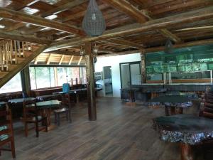 um quarto com mesas e cadeiras num quarto com tectos em madeira em Casa De campo Santuário Bellatrix em Ribeirão Amarelo