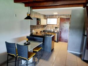 a kitchen with a table and some chairs in a room at Flat com Vista de Luxo! Winterville Gravatá in Gravatá