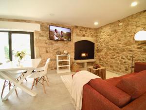 a living room with a couch and a table and a fireplace at The Cliffs - Galleon Amieiro in O Vicedo