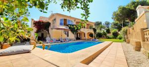 a villa with a swimming pool in front of a house at Villa Haleakala in Moraira