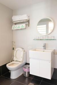 a bathroom with a toilet and a sink and a mirror at Rose Villa in Ruifang