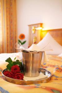 a metal bucket on a tray with roses on a table at Hotel Hirsch mit Café Klösterle in Enzklösterle