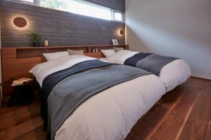 2 Betten in einem Schlafzimmer mit einem großen Fenster in der Unterkunft Terrace Villa Eon in Shirahama