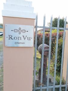 a sign for a house with a fence at RonVu @ Bertram in East London