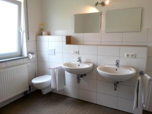 a bathroom with two sinks and a toilet at Ferienwohnung Fasold in Günzburg