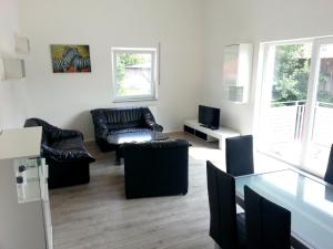 sala de estar con muebles de cuero y TV en Ferienwohnung Fasold en Günzburg