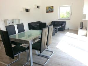 a dining room with a glass table and chairs at Ferienwohnung Fasold in Günzburg
