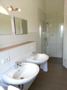 a white bathroom with two sinks and a shower at Ferienwohnung Fasold in Günzburg