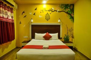 a bedroom with a bed with birds on the wall at Ratna Resort in Khandagiri