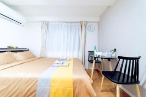 a bedroom with a bed and a table and chairs at nestay inn tokyo ryogoku in Tokyo