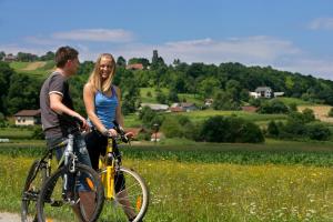a man and a woman on a bike in a field at APARTMAJI KISILAK in Rogašovci