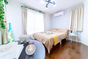 a bedroom with a bed and a table and a window at nestay inn tokyo ryogoku in Tokyo