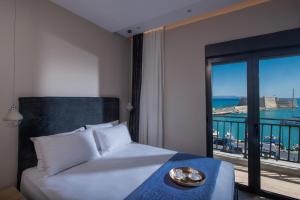1 dormitorio con 1 cama y vistas al océano en Archipelagos apt in the heart of the city, en Heraclión