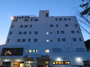 a large white building with cars parked in front of it at 釜石駅から徒歩5分ホテルマルエHotelMarue in Kamaishi