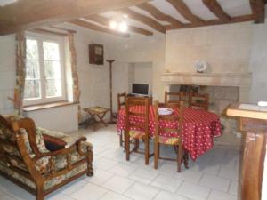 een woonkamer met een tafel en stoelen en een open haard bij Gîte Restigné, 4 pièces, 6 personnes - FR-1-381-236 in Restigné