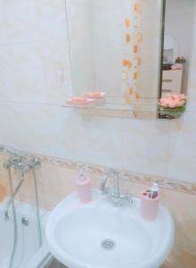 a bathroom with a white sink and a mirror at Студия ЖК Лондон in Syktyvkar