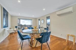 a dining room and living room with a table and chairs at Port View Escape in Bridport