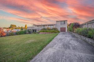 a driveway leading to a house with a cloudy sky at Dune Views in Bridport