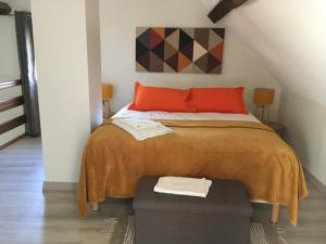 a bedroom with a large bed with red pillows at La Maison d'Emilie - Chambres d'hôtes in Chaumes-en-Brie