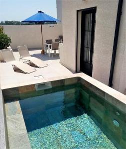 uma piscina em frente a uma casa com um guarda-chuva em La Maison de Laurie em Pézenas