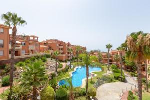 an aerial view of a resort with a pool and palm trees at Apartment 925 in Marbella