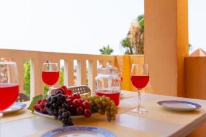 a table with two glasses of wine and a plate of grapes at Apartment 925 in Marbella