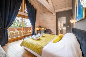 a bedroom with a bed and a large window at Madame Vacances Chalet Etienne in Les Allues