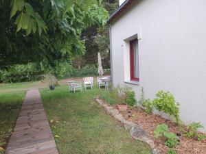 un jardín con mesa y sillas junto a una casa en Gite Ar Pennty en Guérande