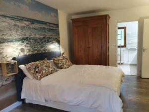 Un dormitorio con una cama blanca con almohadas. en Gite Ar Pennty, en Guérande