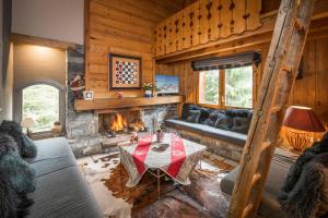 a living room with a couch and a fireplace at Madame Vacances Chalet Etienne in Les Allues
