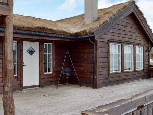 a log cabin with a roof on a deck at Holiday home Aseral II in Tjaldal