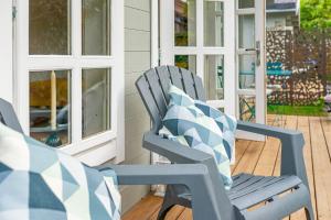 a blue rocking chair with a pillow on a porch at Hygge Lodge Annecy in Doussard