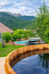 a pool of water with a boat in a yard at Hygge Lodge Annecy in Doussard