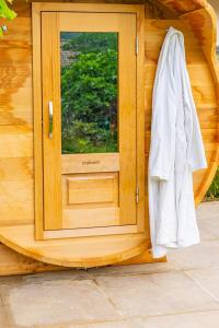 a door of a wooden cabin with a robe next to it at Hygge Lodge Annecy in Doussard