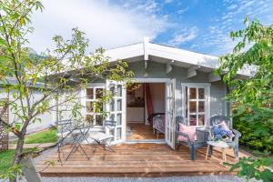 a cottage with a wooden deck and chairs at Hygge Lodge Annecy in Doussard