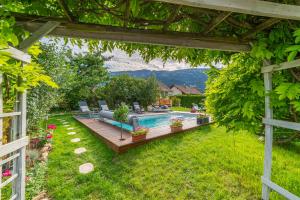 a backyard with a swimming pool and a pergola at Hygge Lodge Annecy in Doussard