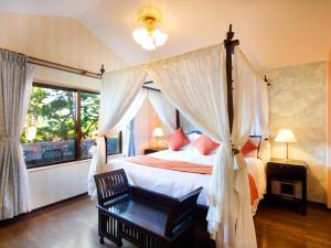 a bedroom with a canopy bed and a window at Coco Garden Resort Okinawa in Uruma +84 photos