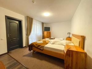 a bedroom with a large bed and a window at PENSIUNEA TEOMIR in Pojorâta +104 photos