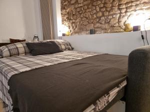 a bedroom with a bed and a stone wall at Pantheon, Campo de fiori mini garden in Rome