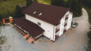 an overhead view of a white house with a brown roof at PENSIUNEA TEOMIR in Pojorâta