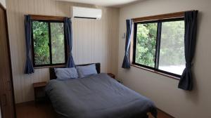 1 dormitorio con 1 cama y 2 ventanas en 松田テラスB Matsuda Terrace B, en Matsuda