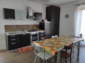 eine Küche mit einem Tisch und Stühlen sowie eine Küche mit einem Waschbecken in der Unterkunft Marone Villa con Giardino Vista Lago Private Parking in Marone