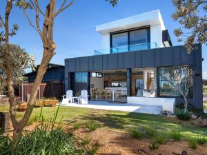 uma casa moderna com uma fachada de vidro em Banksia I Absolute Beachfront em Culburra Beach