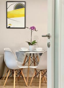 スタラ・ザゴラにあるCity Centre Bright & Cozy Apartment for 4 personsのダイニングルームテーブル(白い椅子付)、花瓶