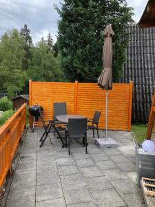 patio z parasolem, stołem i krzesłami w obiekcie Ferienhäuser 6 & 24 w mieście Freyung