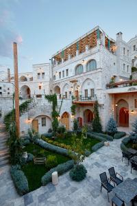a large stone building with a garden in front of it at Exedra Cappadocia in Ortahisar